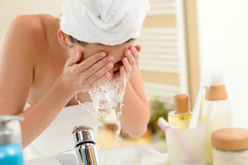 Женщина умывает лицо Женщина умывает лицо